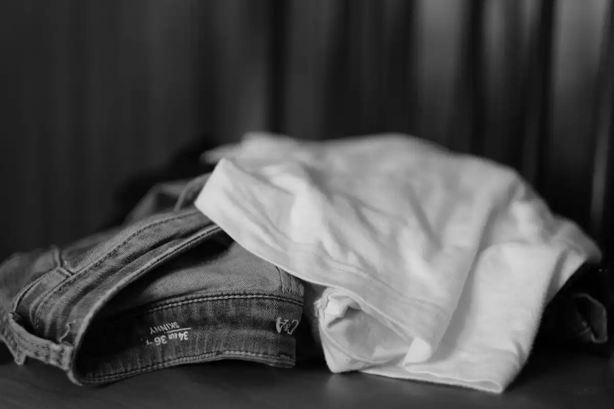 Blugi și tricou împăturiți, fotografiați alb-negru în prim-plan