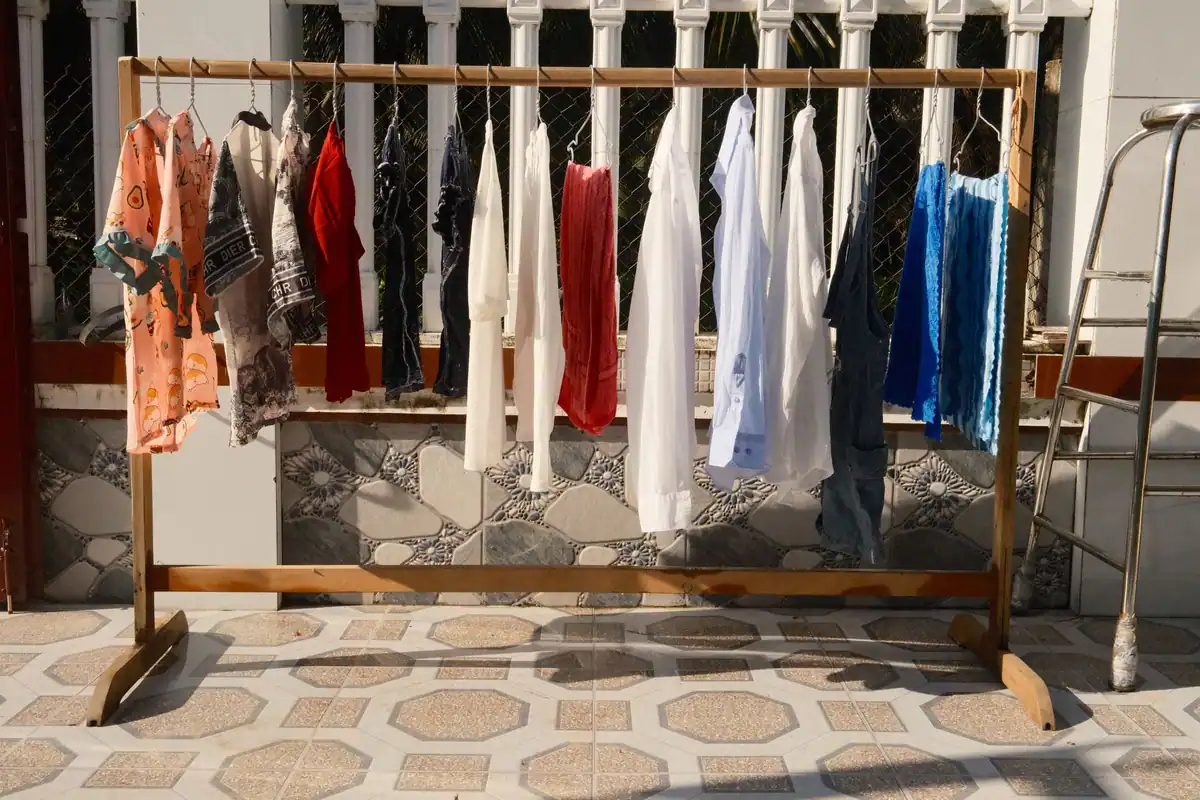 Haine colorate întinse la uscat în bătaia soarelui, pe sârmă afară